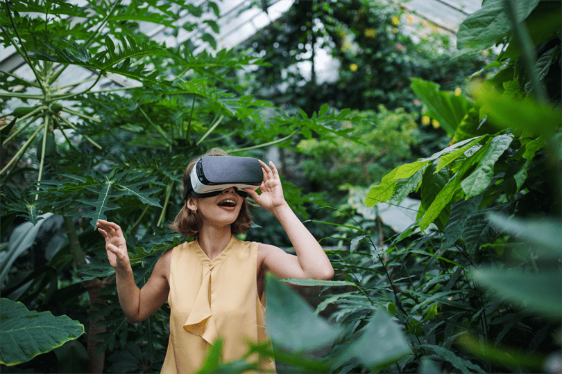 Frau mit VR Brille zwischen Pflanzen; Vision