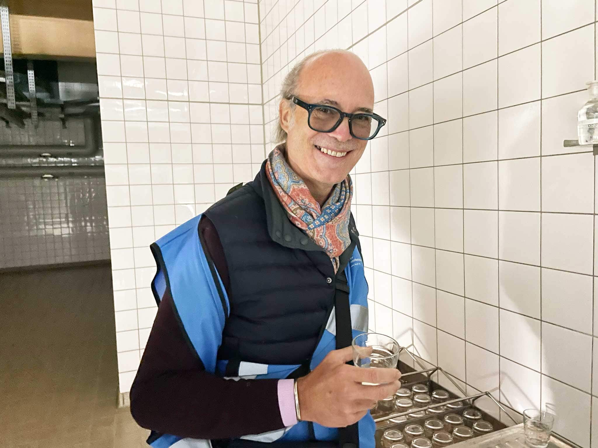 Oliver N. Hagedorn bei einer Werksführung der Berliner Wasserbetrieben. Er hält ein Glas mit Trinkwasser in der Hand und lächelt in die Kamera.