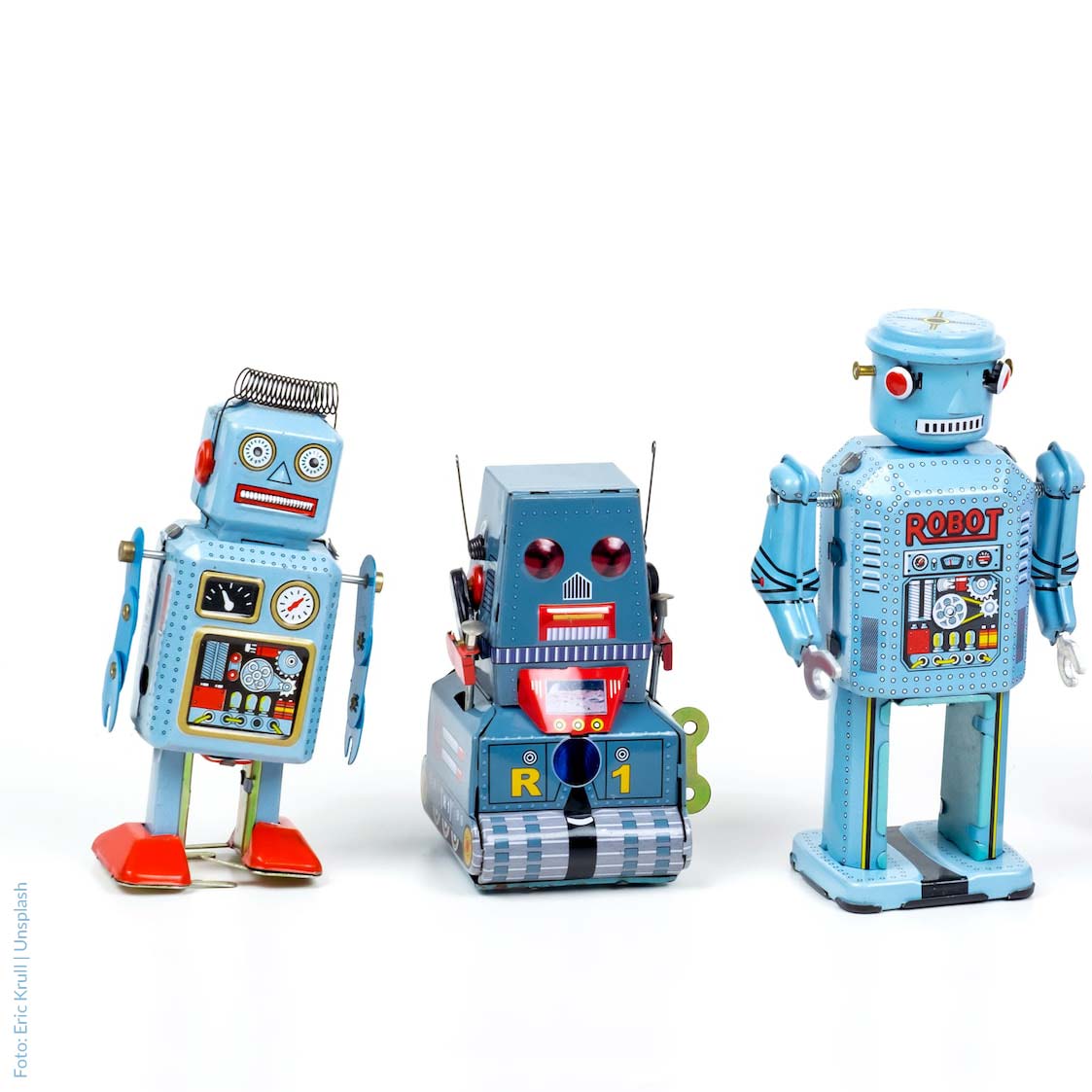 Drei Retro-Spielzeugroboter in Blau vor weißem Hintergrund
