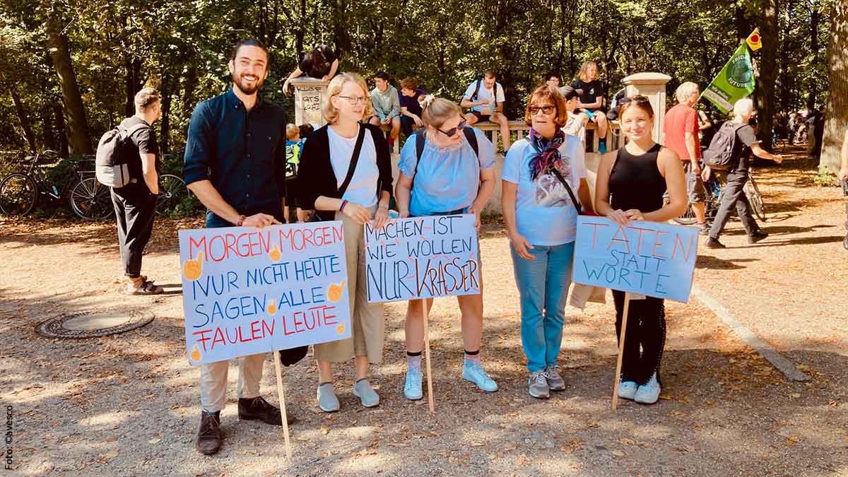 Mitarbeitende von avesco beim Klimastreik 2023 in Berlin. Fünf Mitarbeitende mit Protestschildern bei der Demo