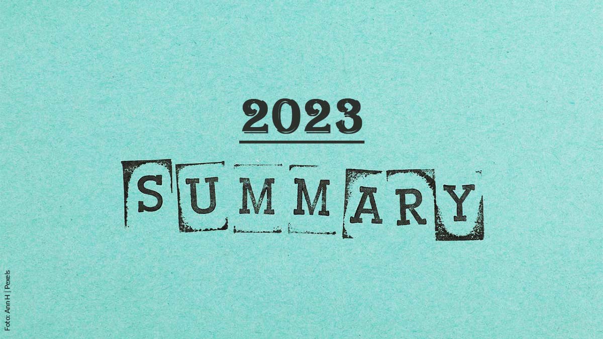 Türkisfarbener Untergrund mit Papierfaserung. Text "2023 Summary" im Stempelformat